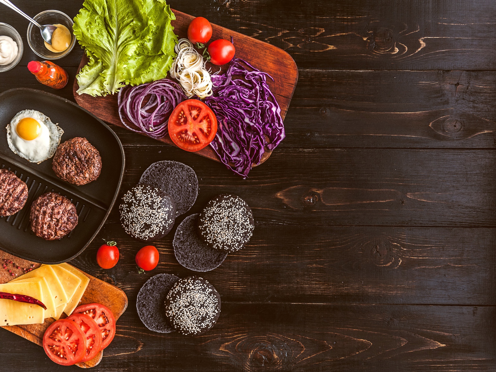 Повар готовит гамбургеры на деревянном столе