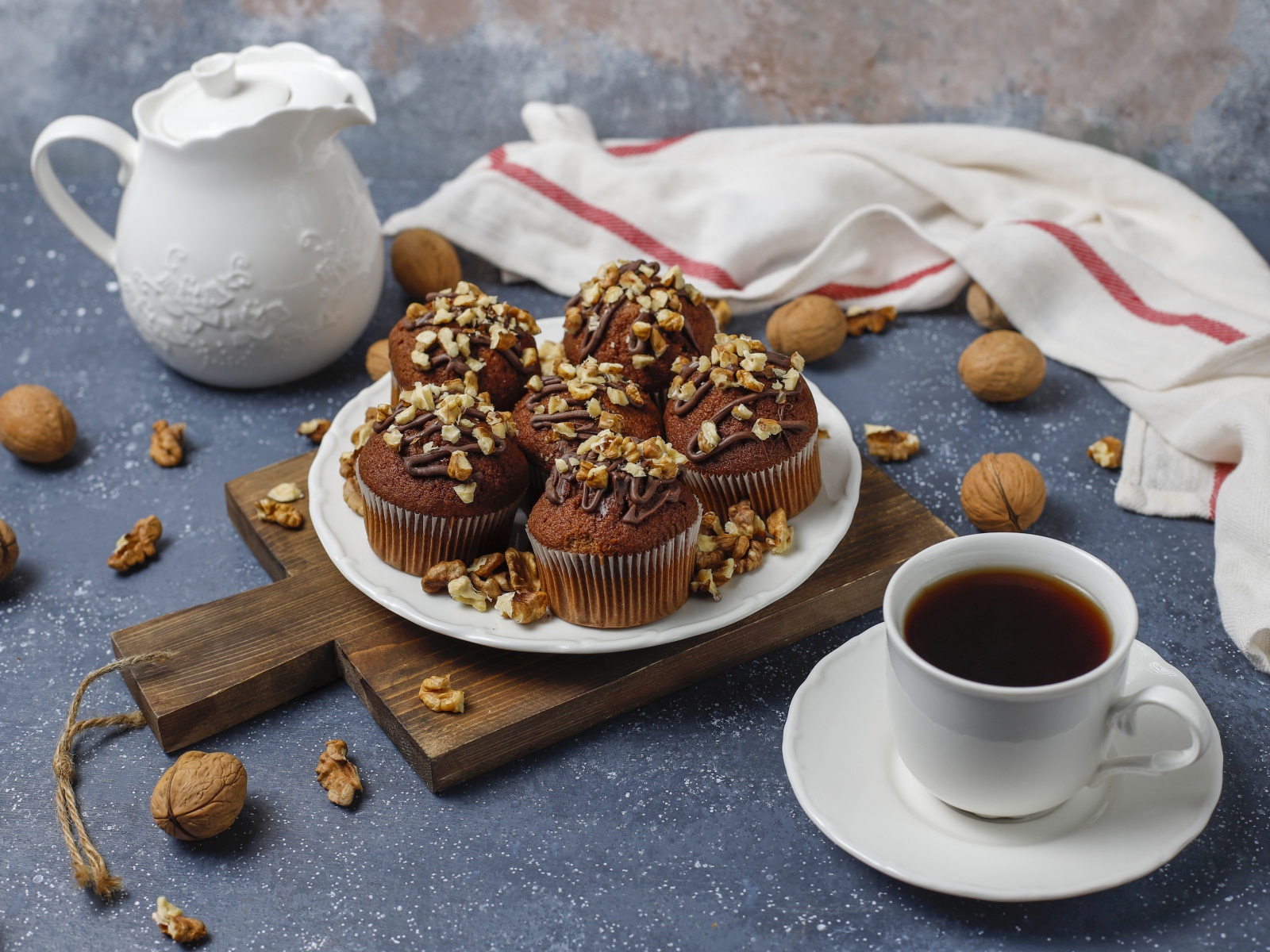 Вкусные шоколадные кексы с орехами на столе с кофе