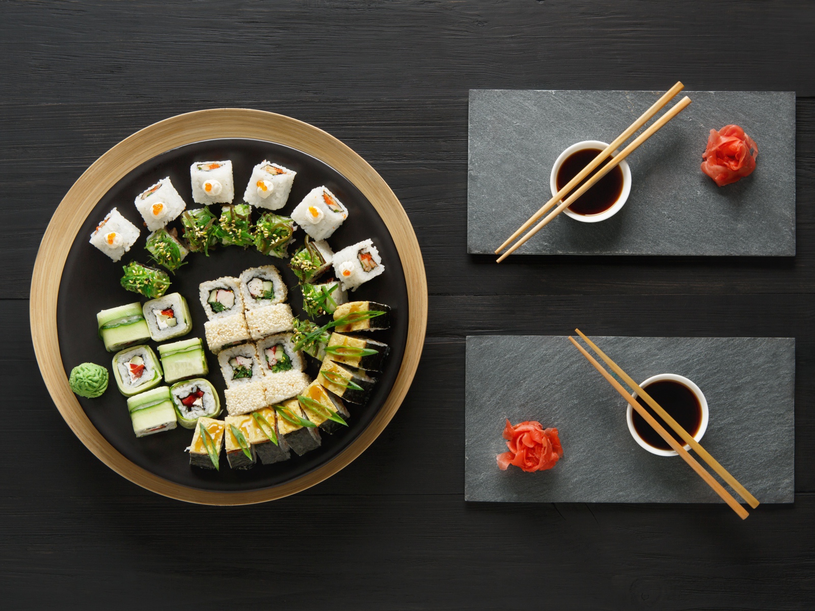 Вкусные  роллы на столе с соевым соусом и палочками 