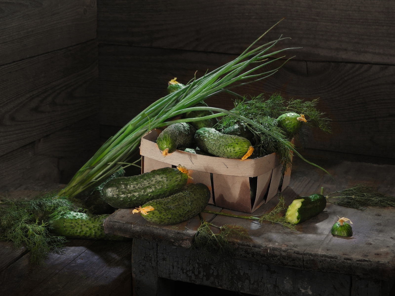 Свежие огурцы на столе  с зеленым луком и укропом