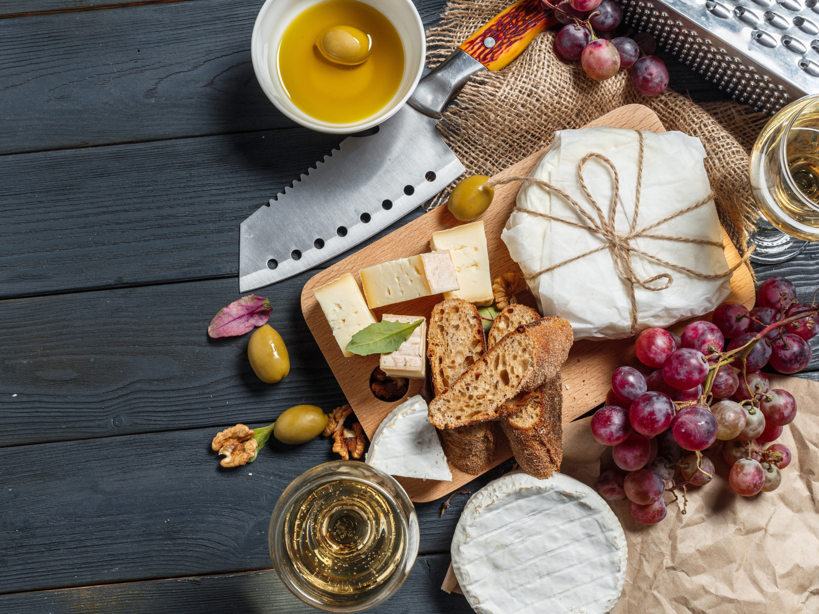 Виноград на столе с сыром, хлебом и оливками