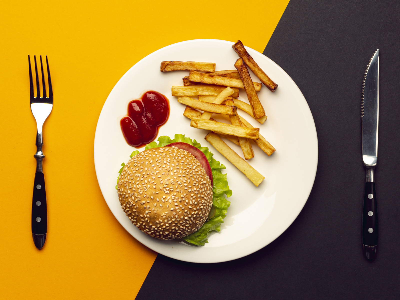 Гамбургер на белой тарелке с соусом и картофелем фри