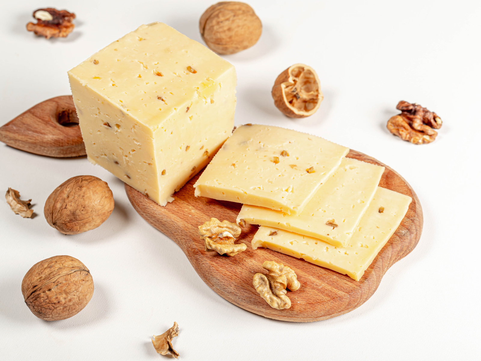 Твердый сыр на доске с грецкими орехами 