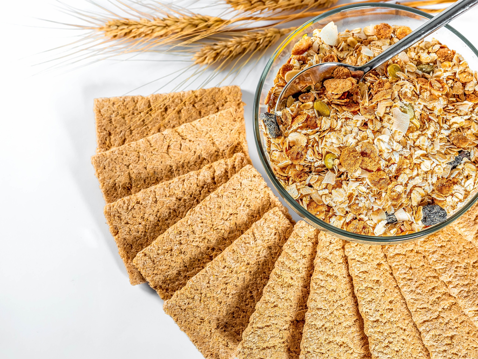 Мюсли в тарелке на столе с хлебцами 