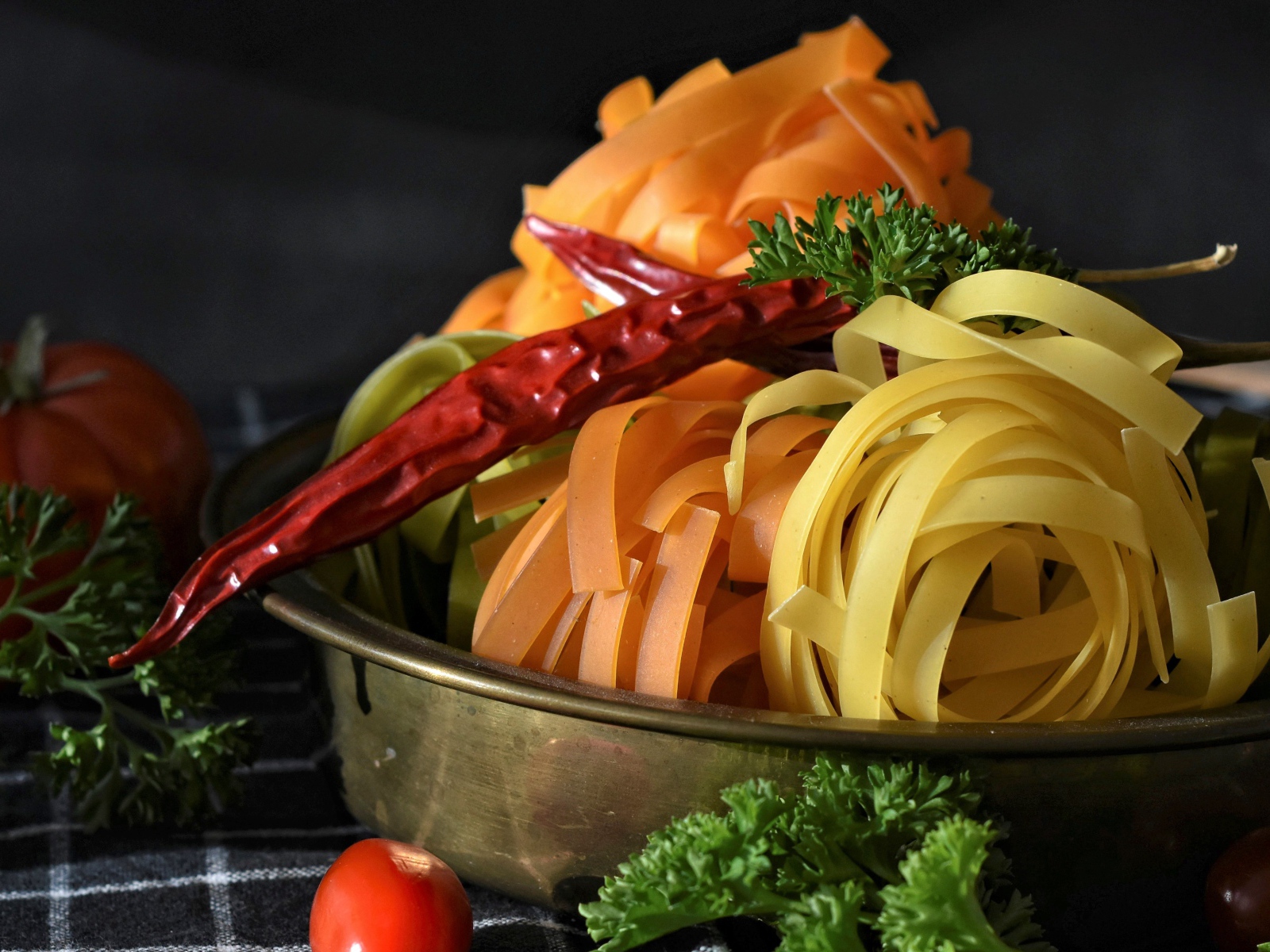 Сырая лапша на столе с острым перцем и петрушкой