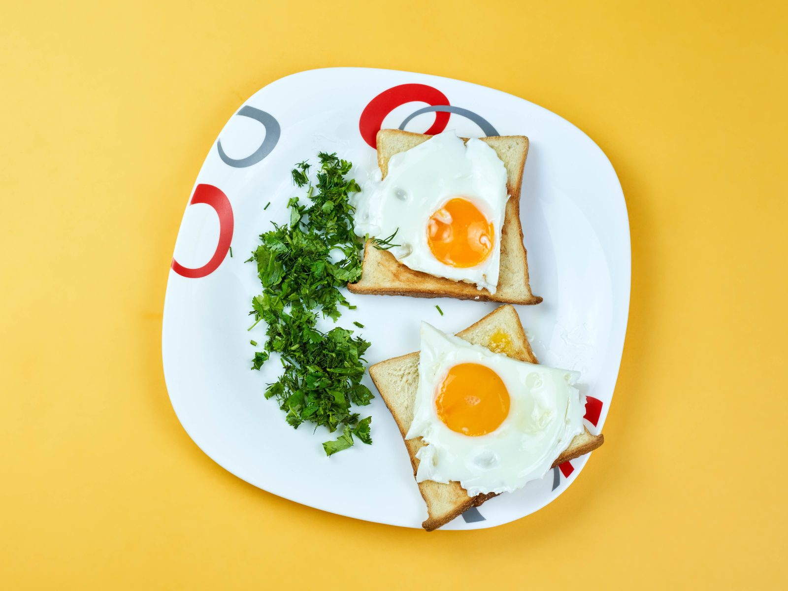 Тосты с яичницей на тарелке с зеленью петрушки 