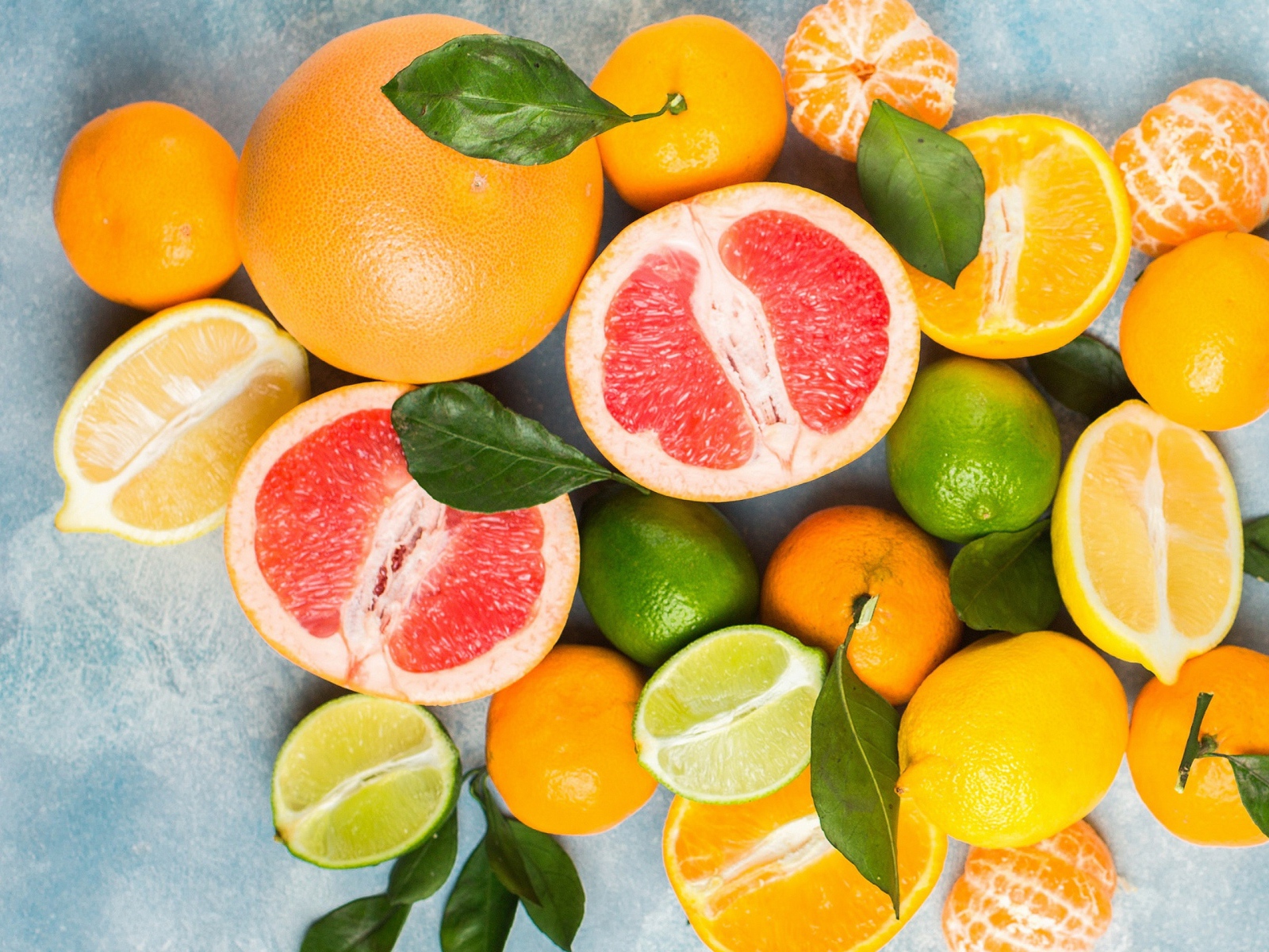 Аппетитные цитрусовые фрукты с зелеными листьями