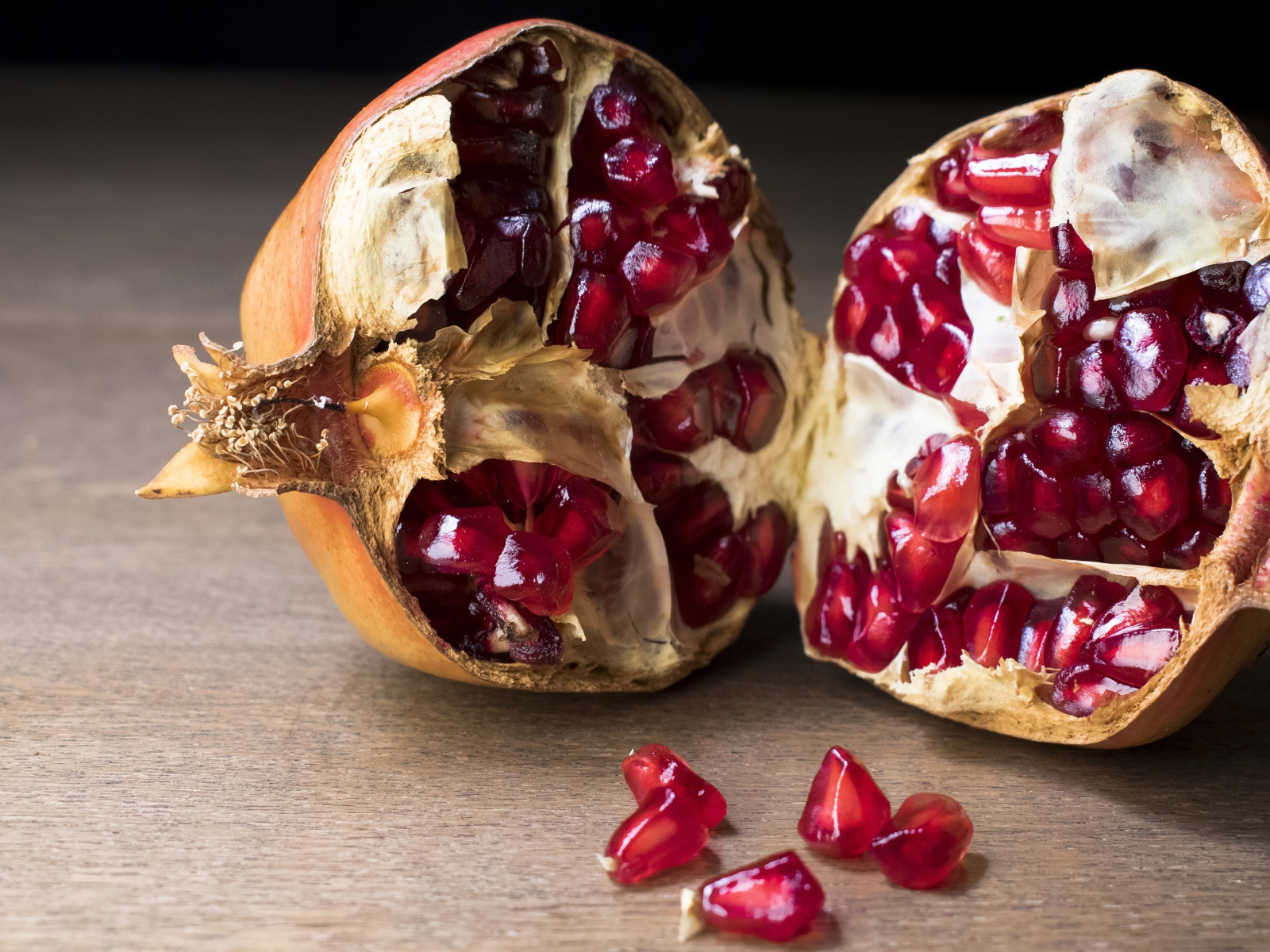 Разломанный красный гранат на столе 