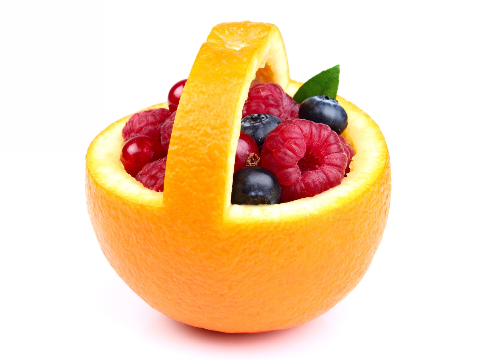 Свежие ягоды в кожуре апельсина на белом фоне