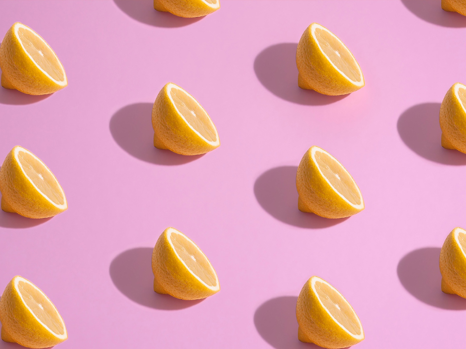 Половинки лимона на розовом фоне
