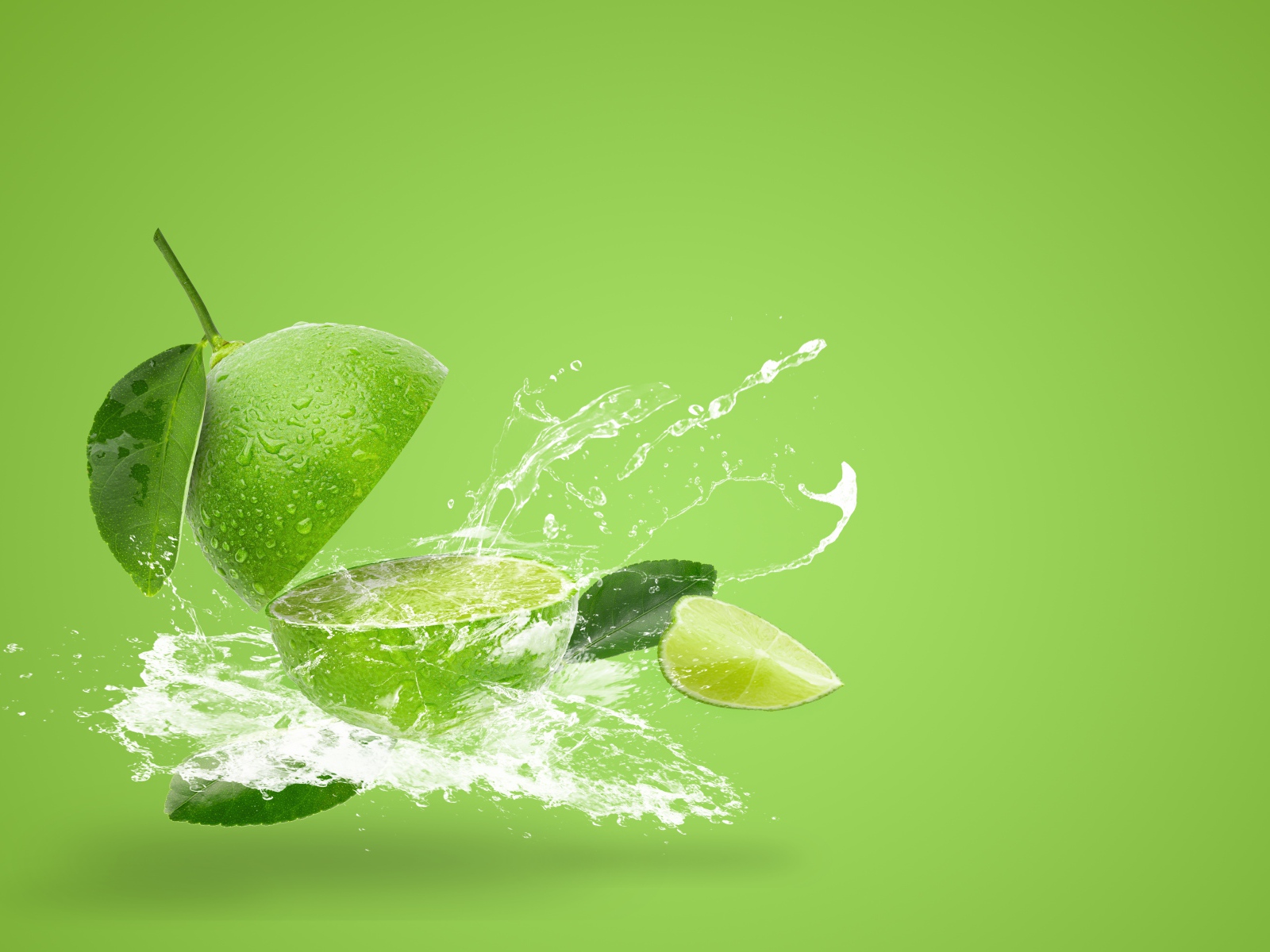 Лайм в брызгах воды на зеленом фоне
