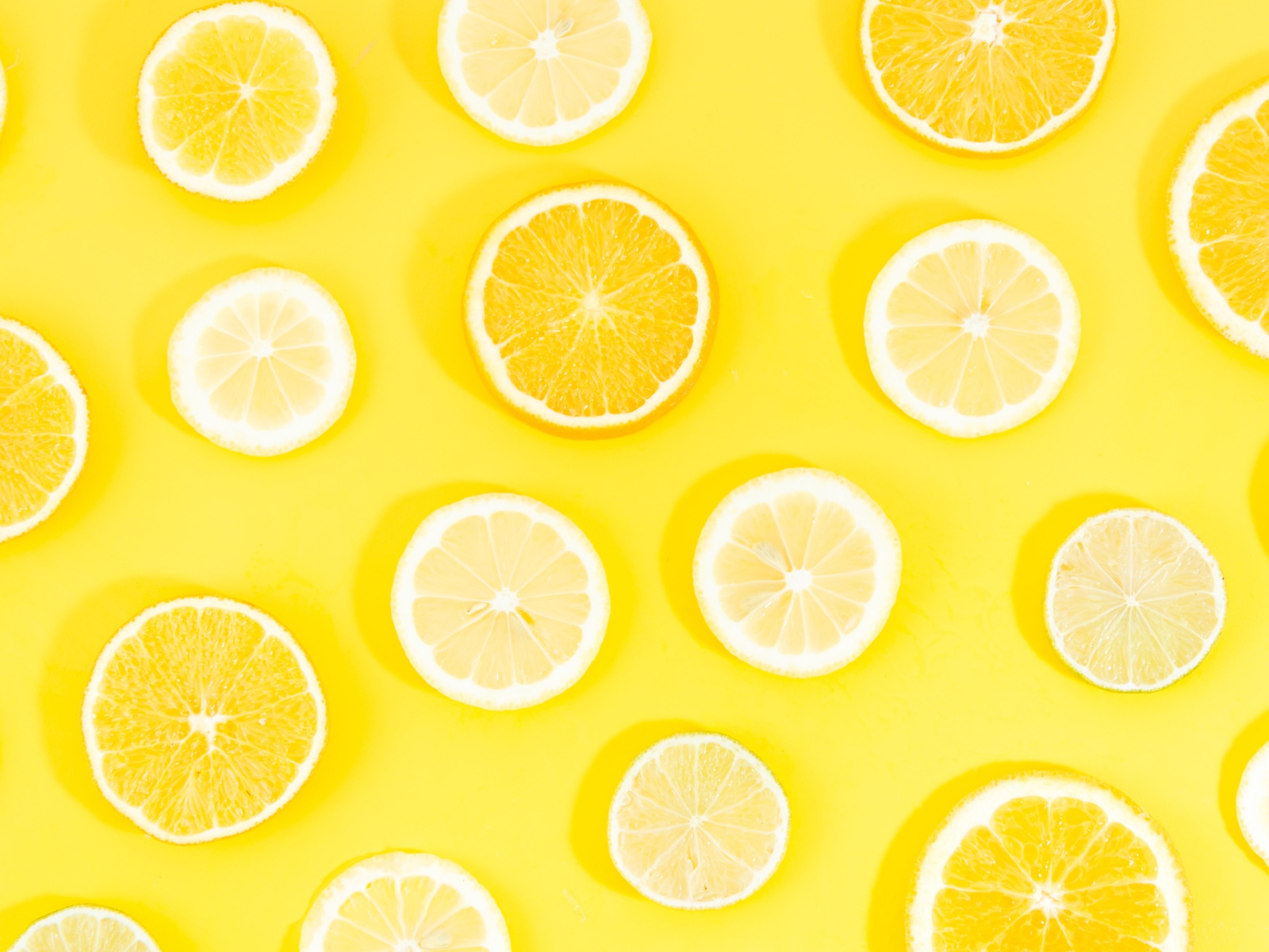 Кружочки апельсина и лимона на желтом фоне