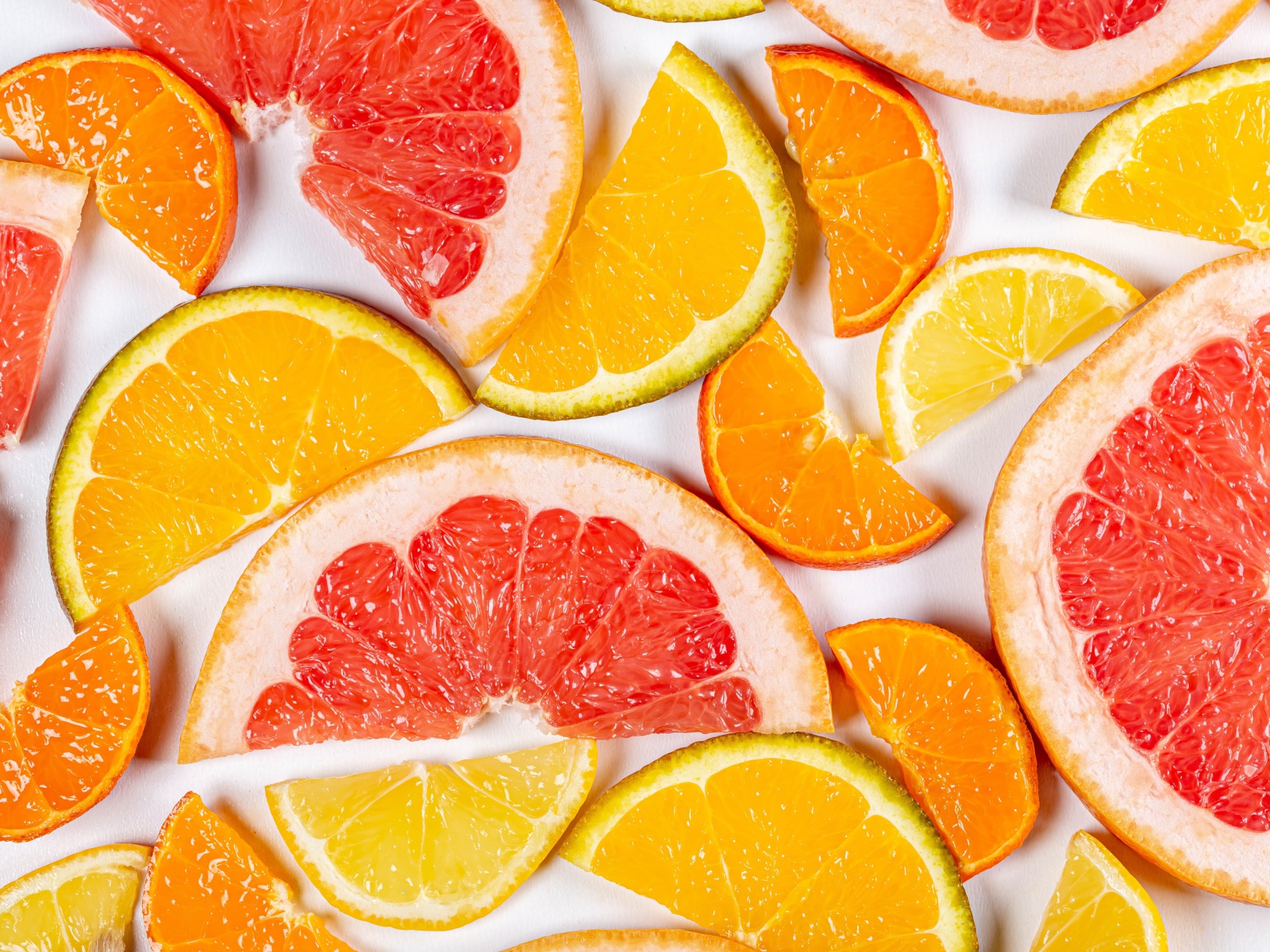 Кусочки апельсина, лимона и грейпфрута на белом фоне