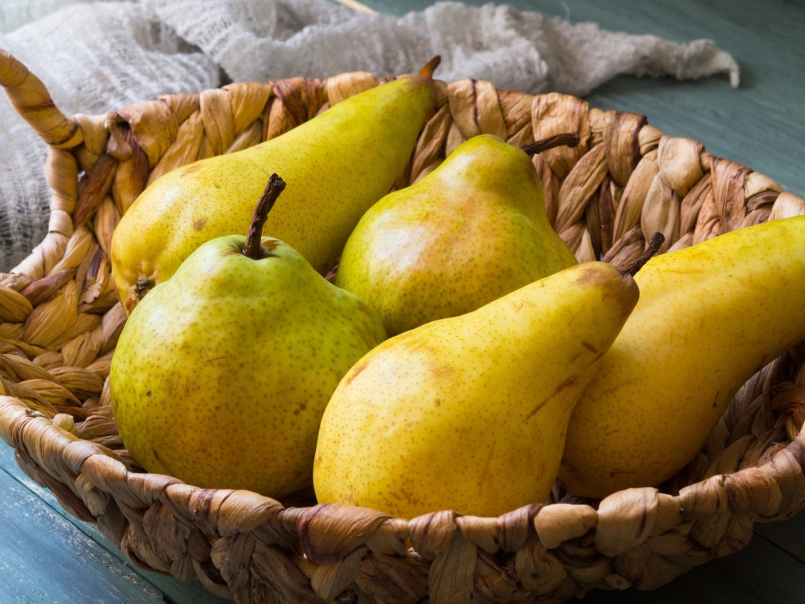 Спелые груши лежат в корзине на столе