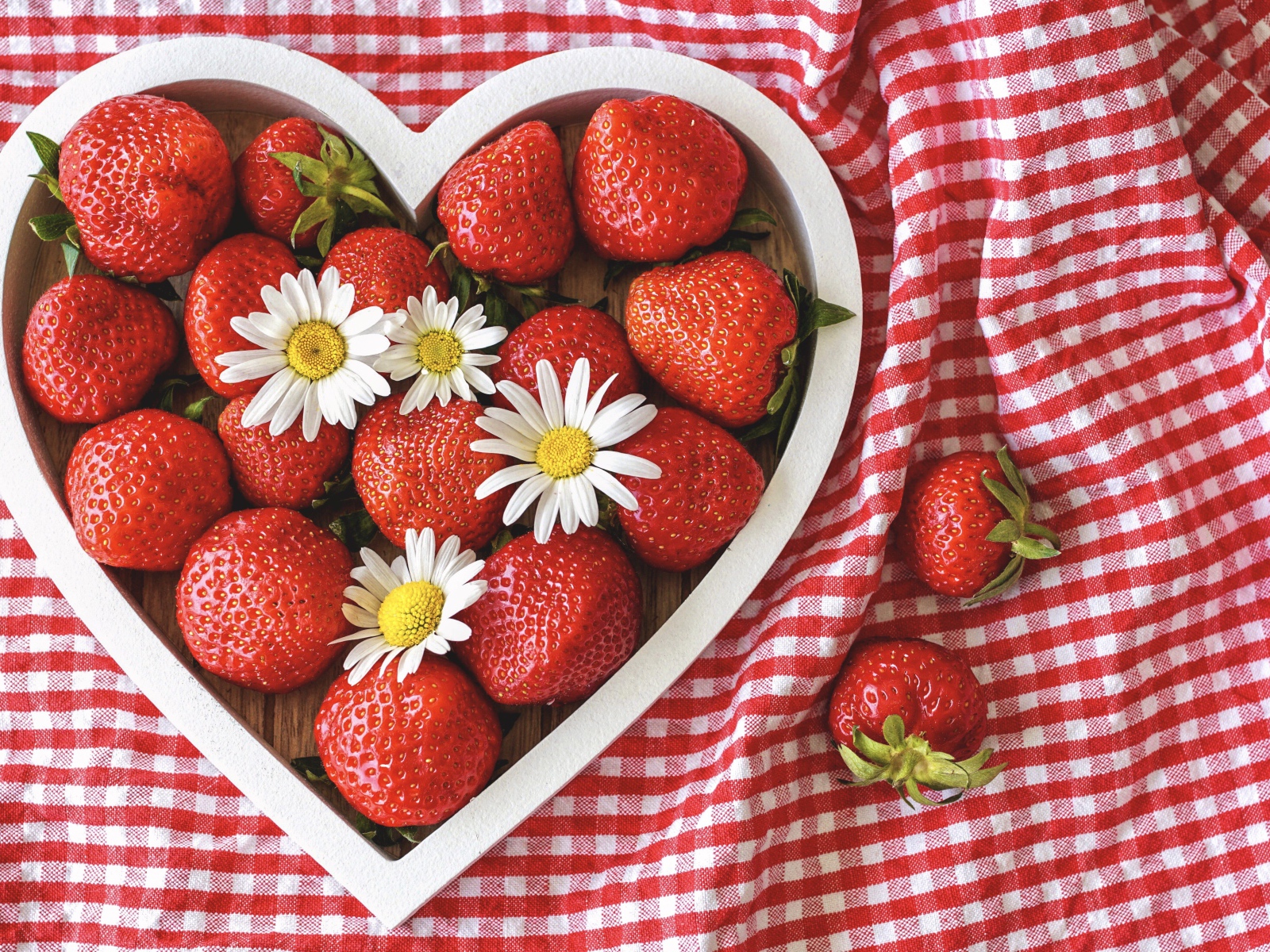 Спелая красная клубника в коробке в форме сердца с ромашками
