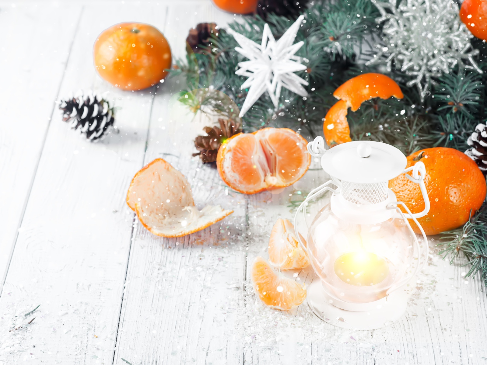 Мандарины и еловая ветка на столе с лампой