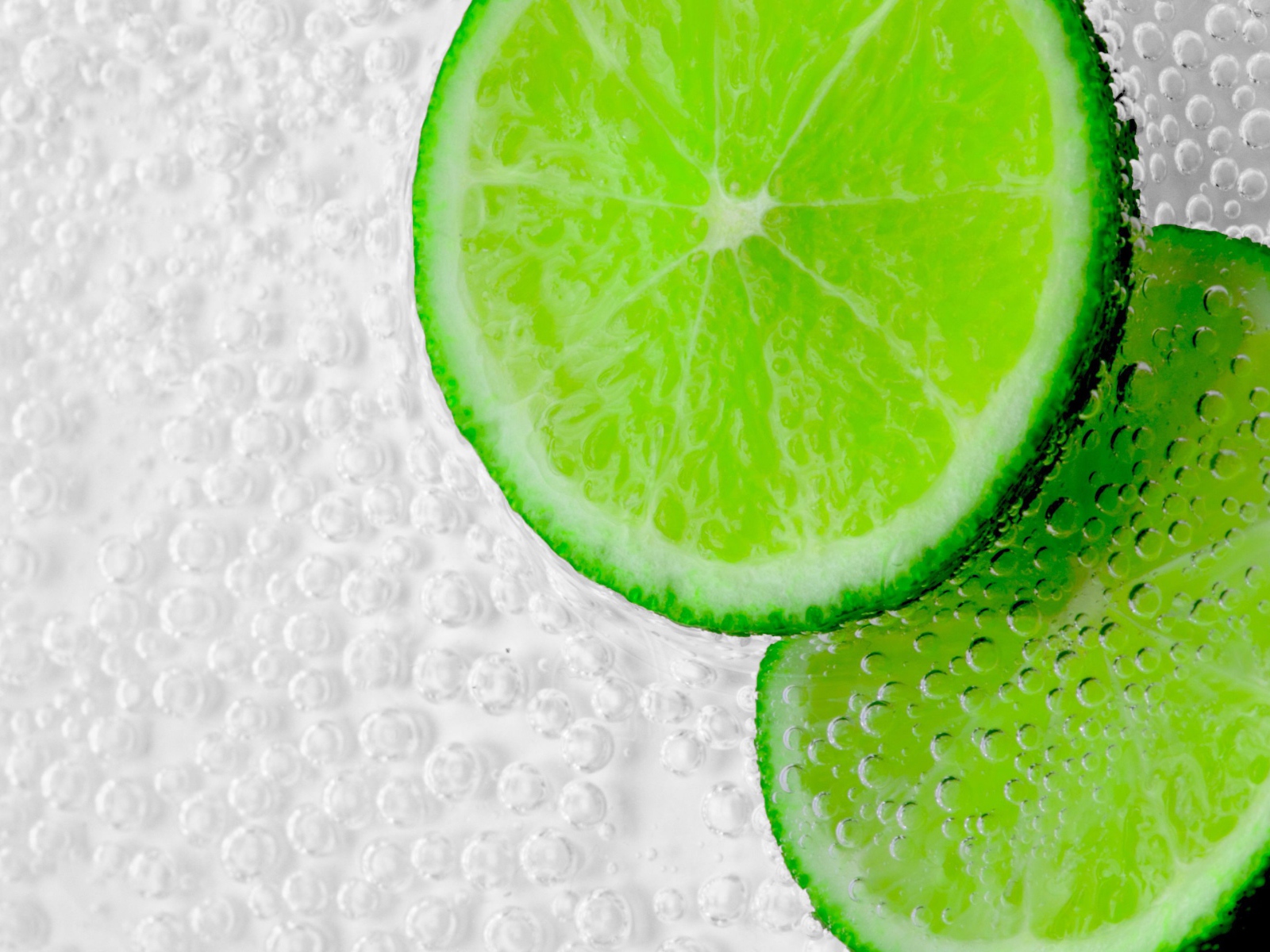 Два куска лайма в пузырях в воде 