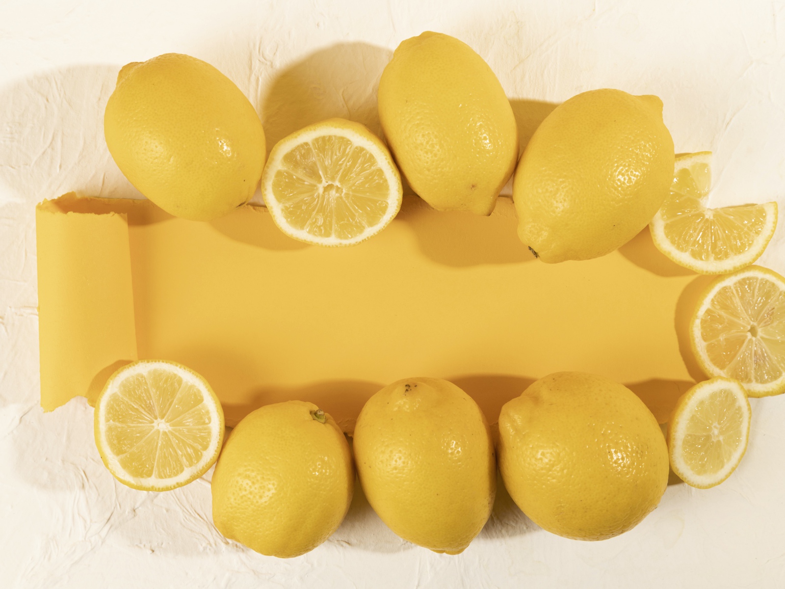 Желтые лимоны на белом фоне с листом бумаги