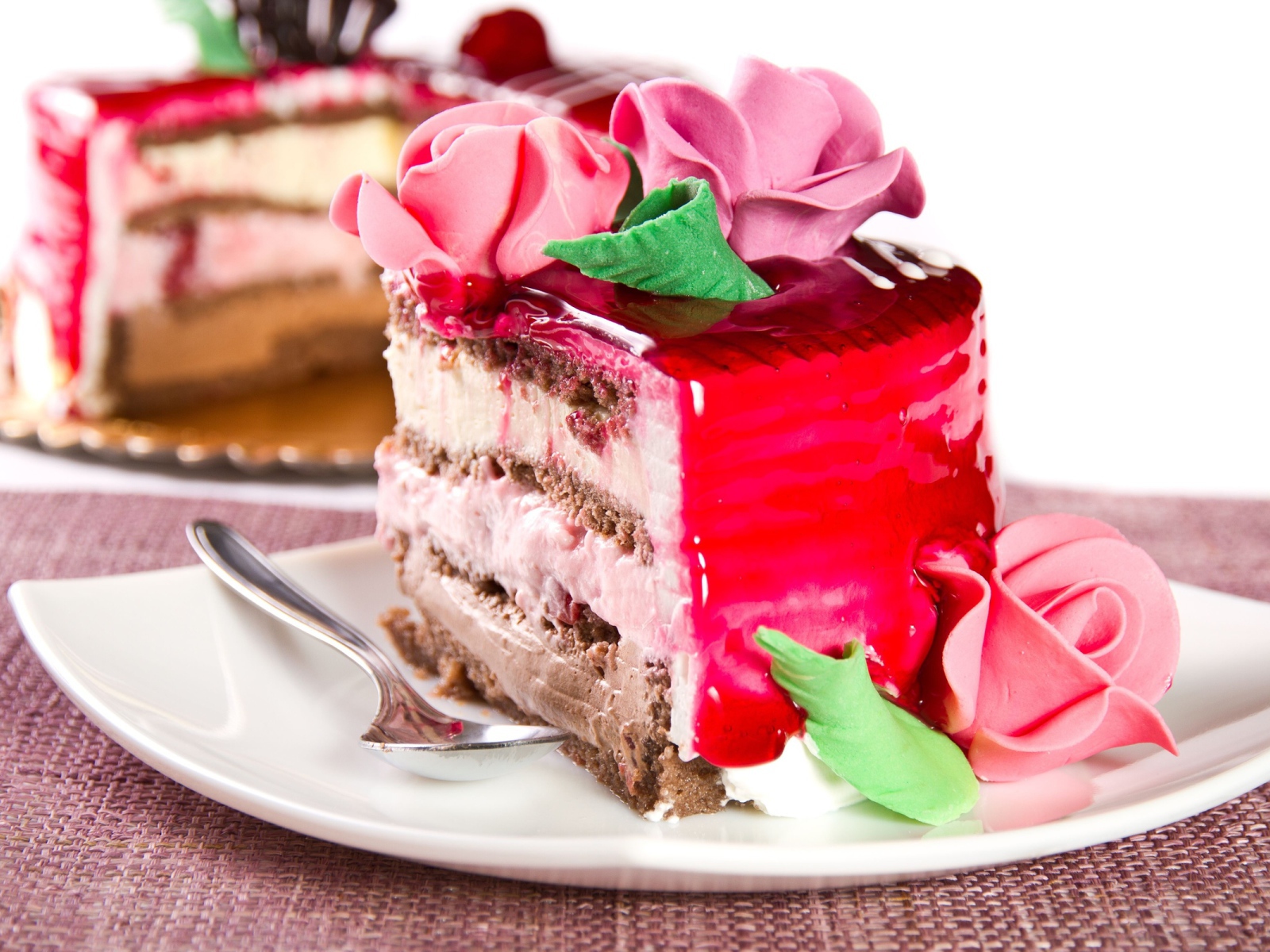 Кусок аппетитного торта декорирован розами из крема