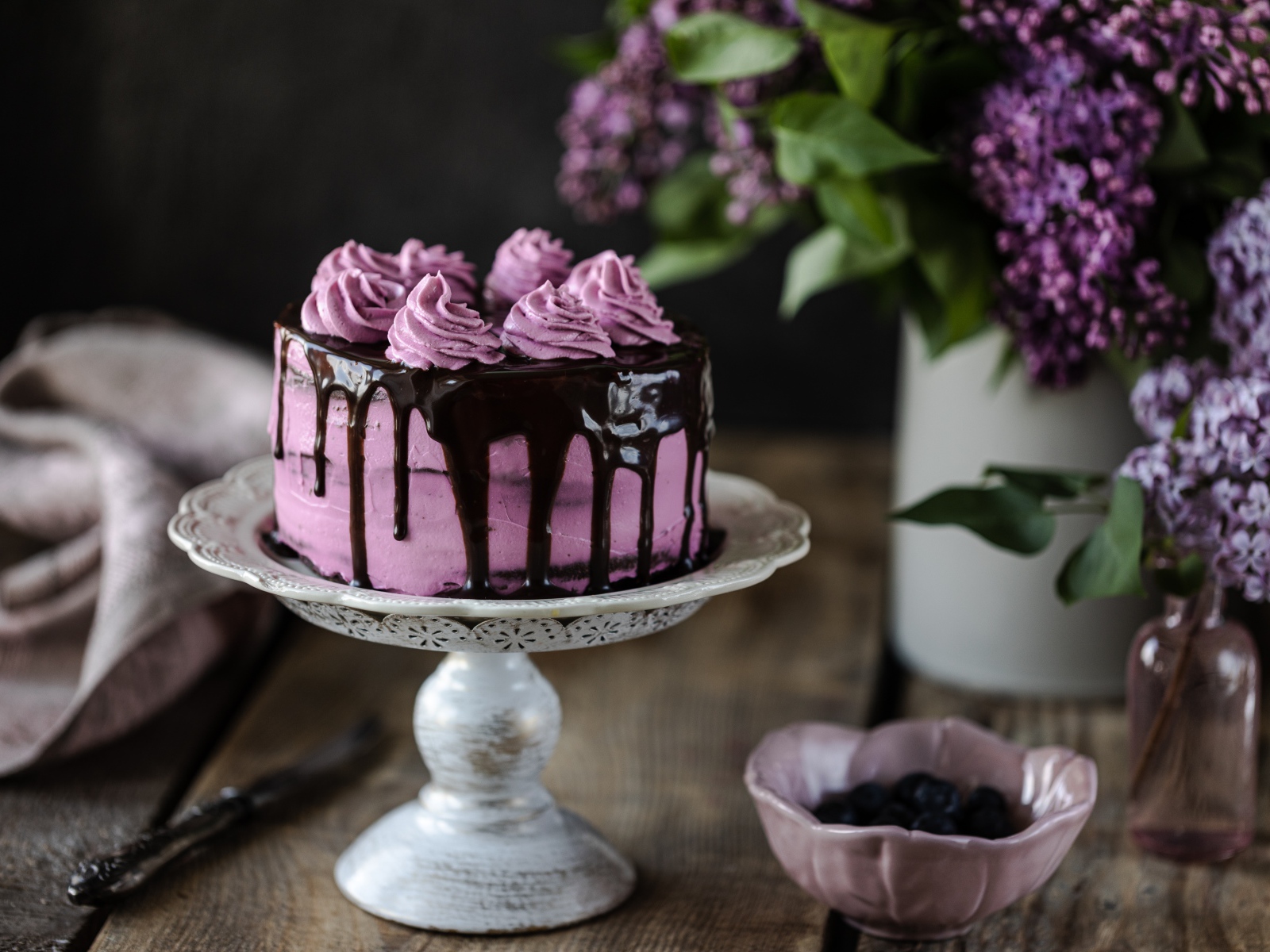 Ягодный торт с шоколадом на столе с сиренью 