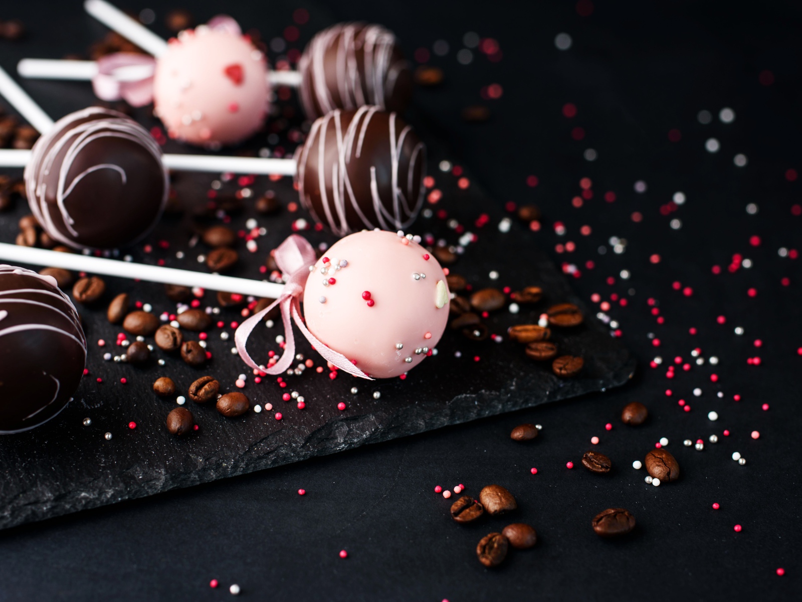 Шоколадные шарики на палочке на столе с кофейными зернами