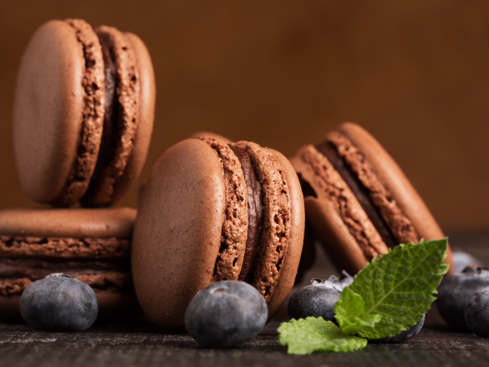 Шоколадный десерт макарон на столе с черникой 