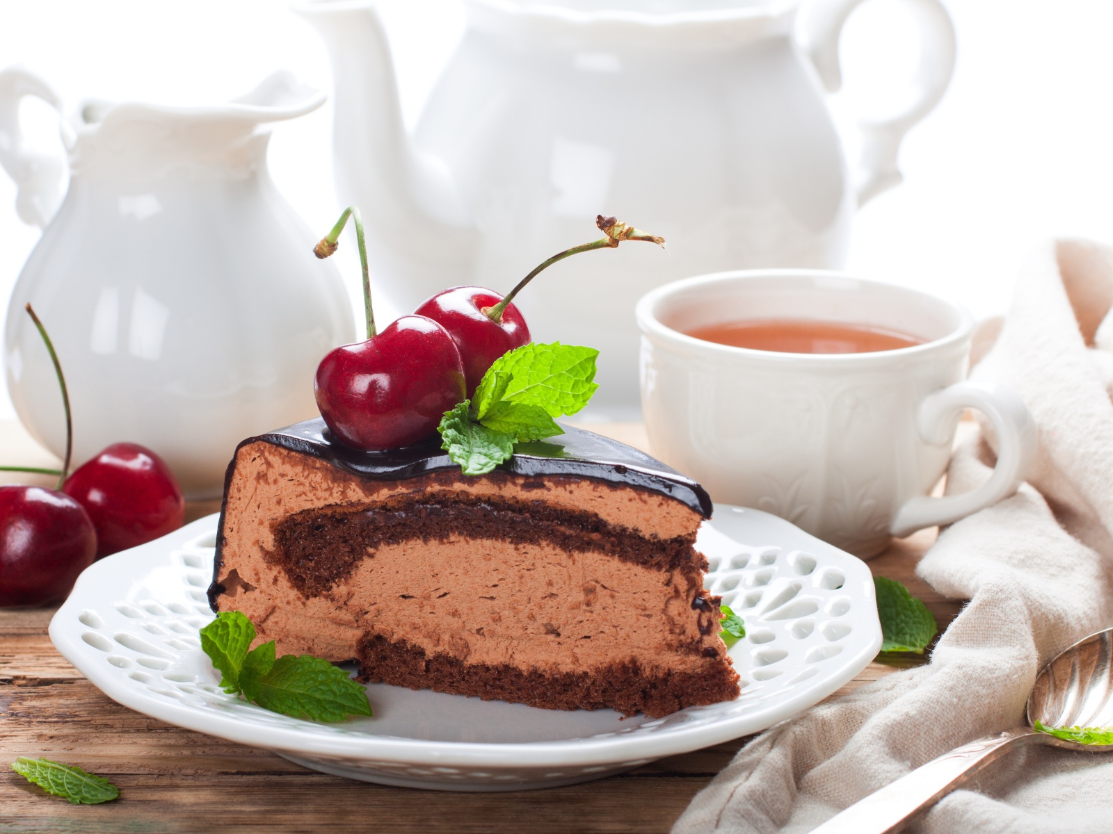 Торт с суфле в шоколаде с ягодами черешни на столе с чаем