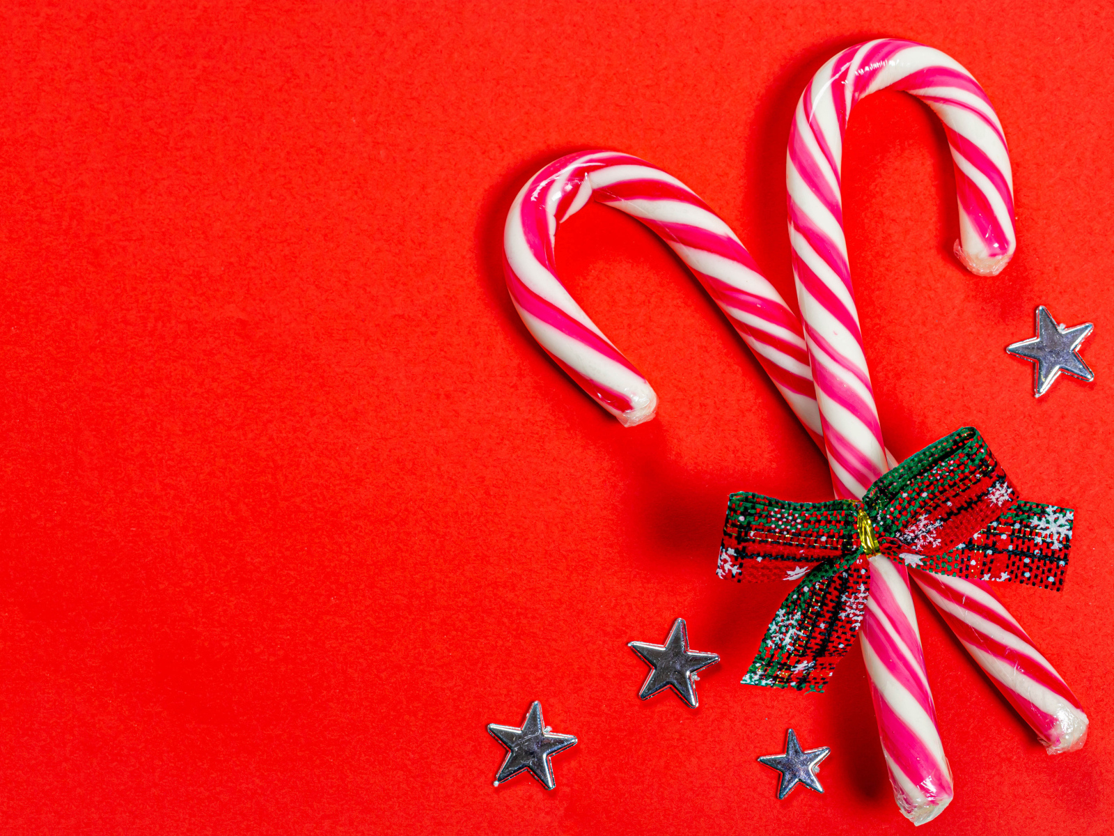 Рождественские леденцы с бантом на красном фоне