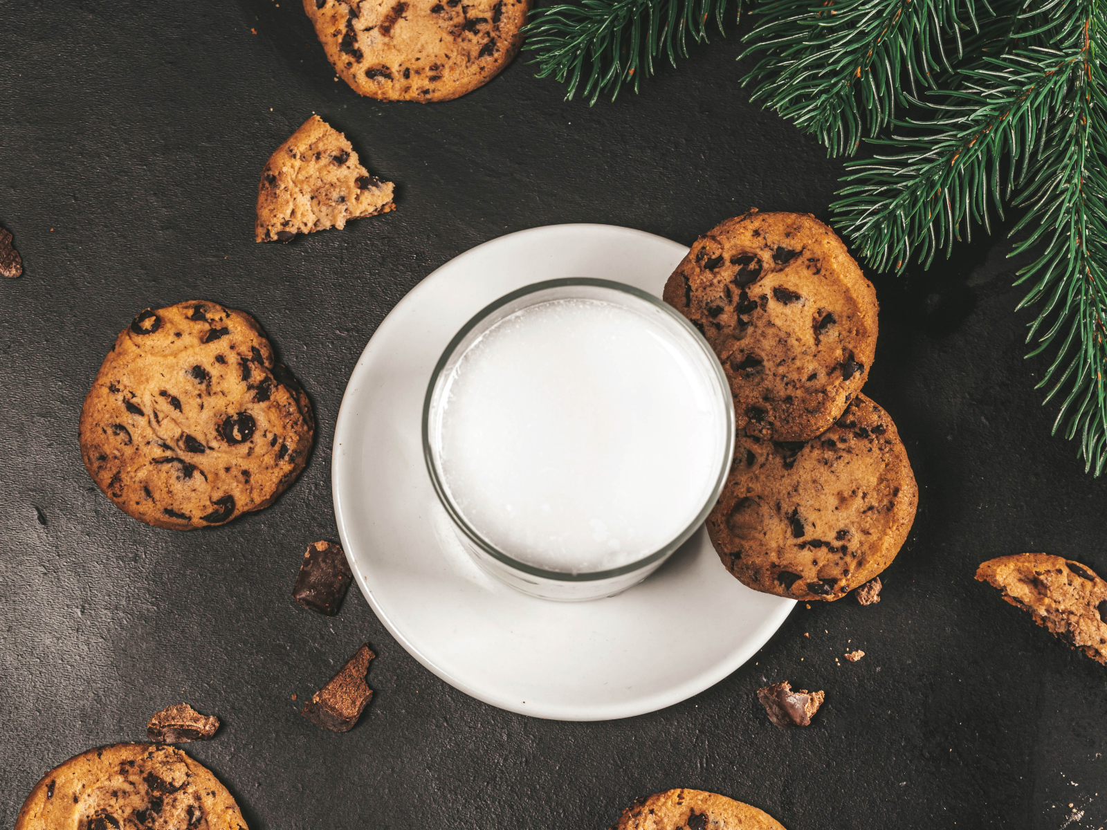 Печенье с шоколадом на столе со стаканом молока 