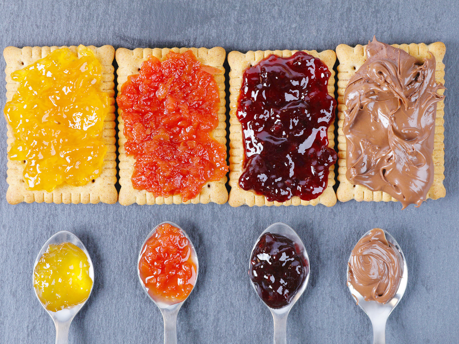 Крекеры с джемом и шоколадной пастой на столе 