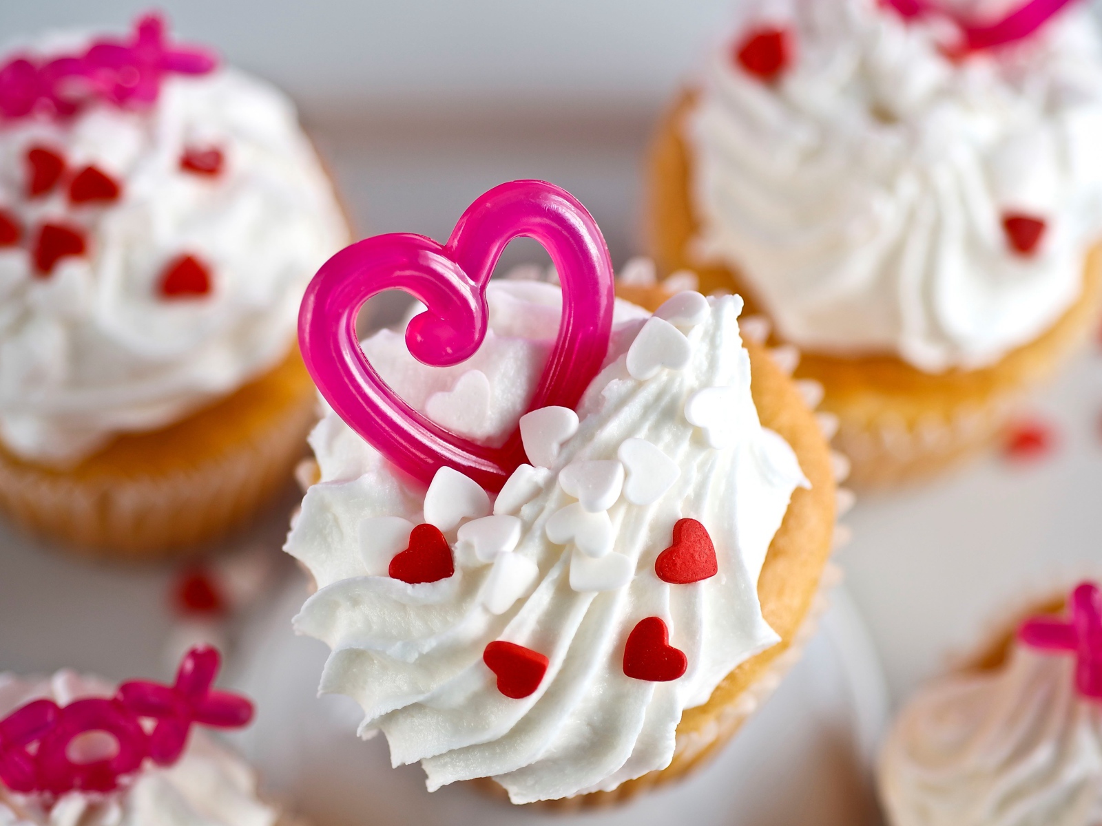Кексы с кремом и сердечками на столе 