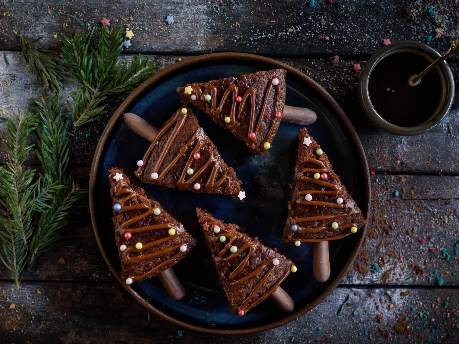 Вкусное шоколадное печенье с еловыми ветками и кофе на столе