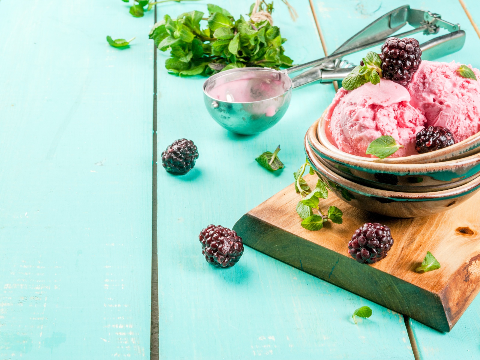 Шарики мороженого на столе с ягодами черники и мятой