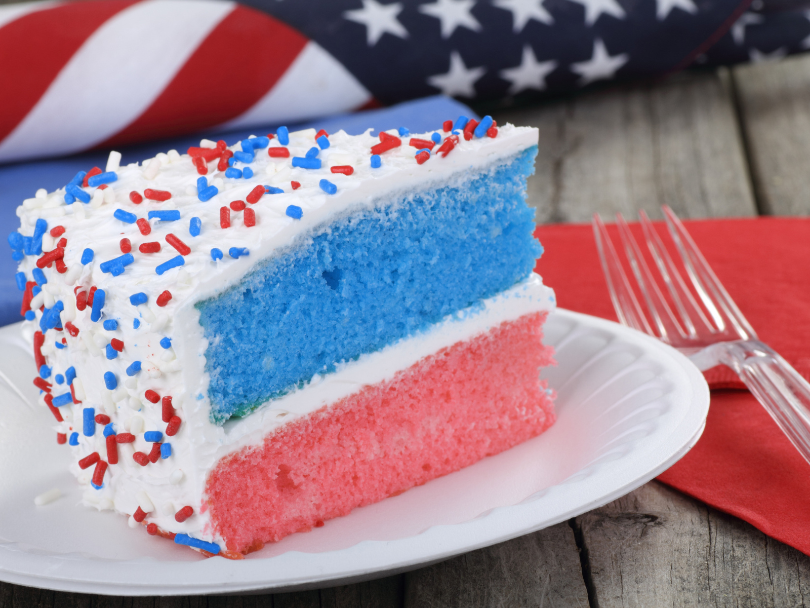 Разноцветный торт на тарелке с кремом