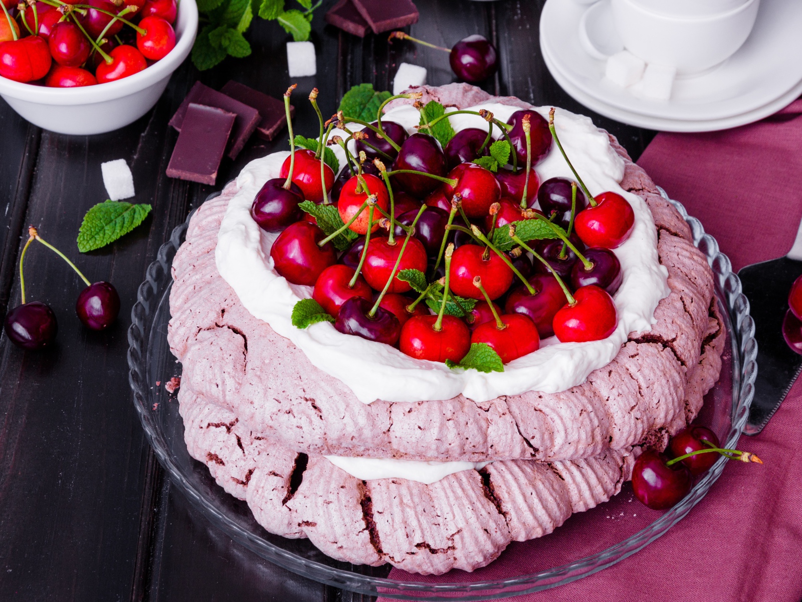 Торт Павлова со сливками и ягодами черешни на столе