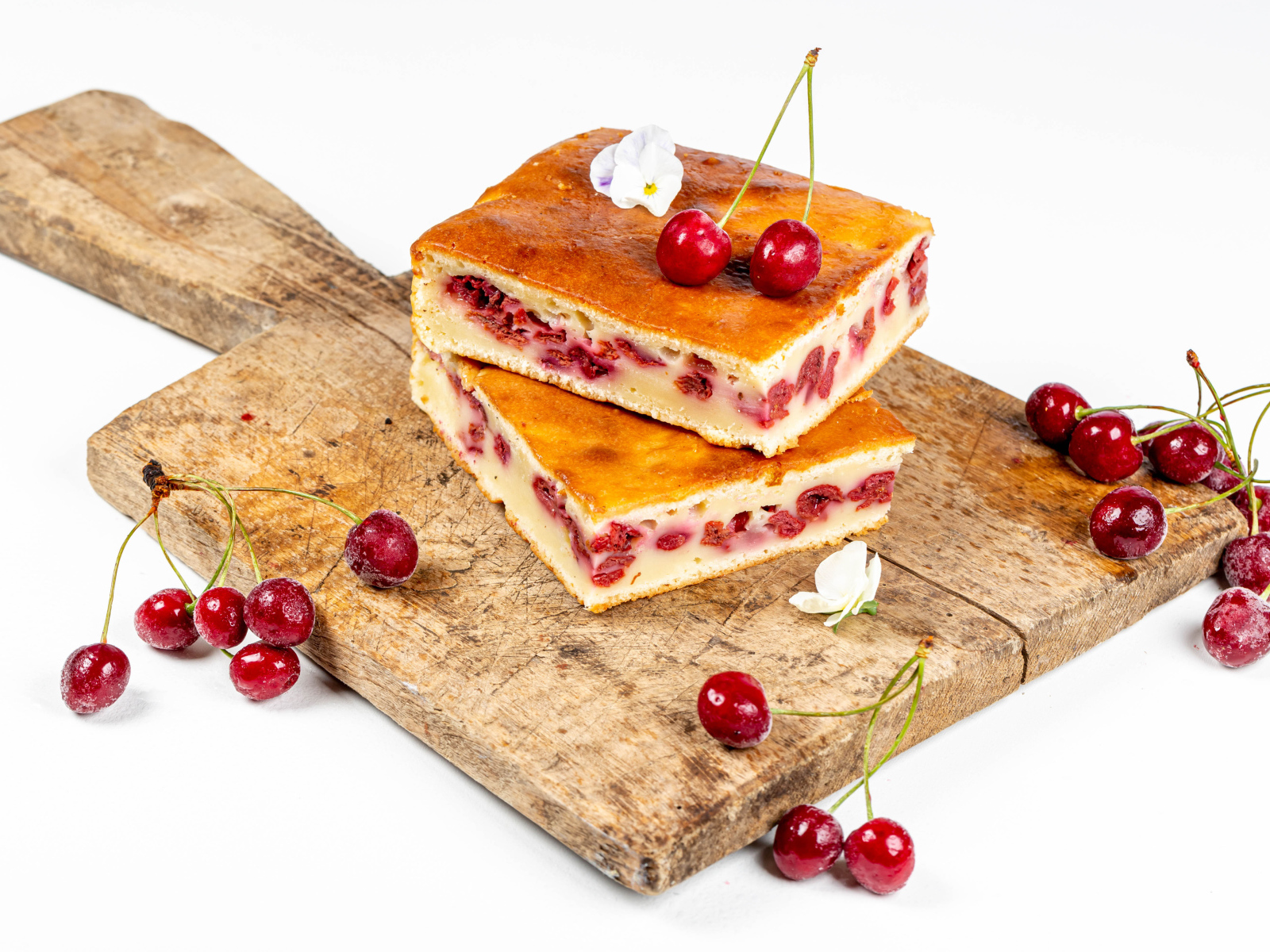 Пирог с вишнями на доске на белом фоне