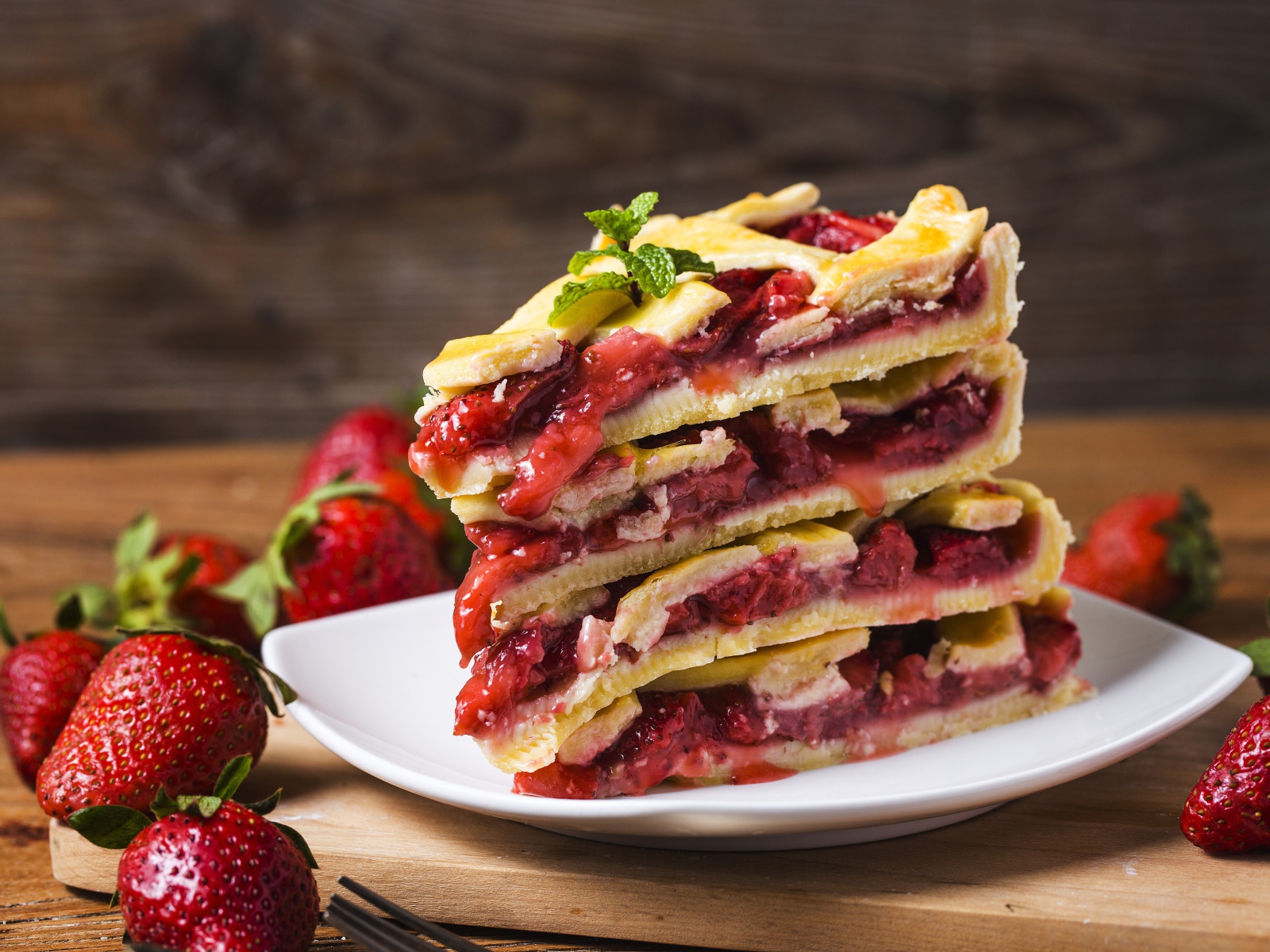 Пирог с ягодами клубники на белой тарелке 