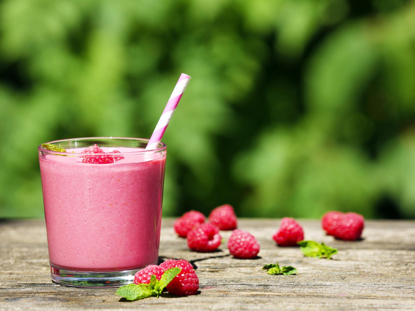 Коктейль в стакане с трубочкой и ягодами малины