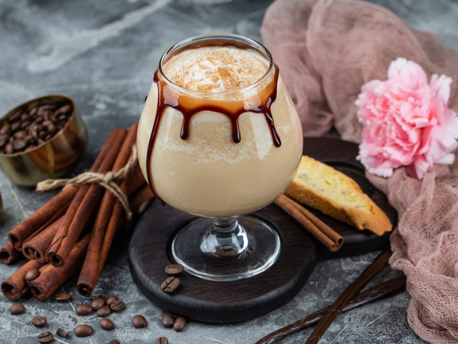 Вкусный кофейный напиток на столе с корицей и гвоздикой