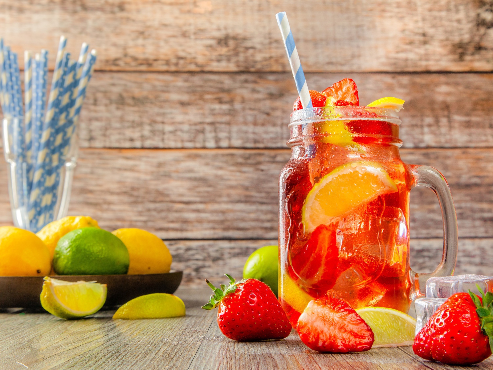 Напиток с клубникой и лимоном в банке на столе 