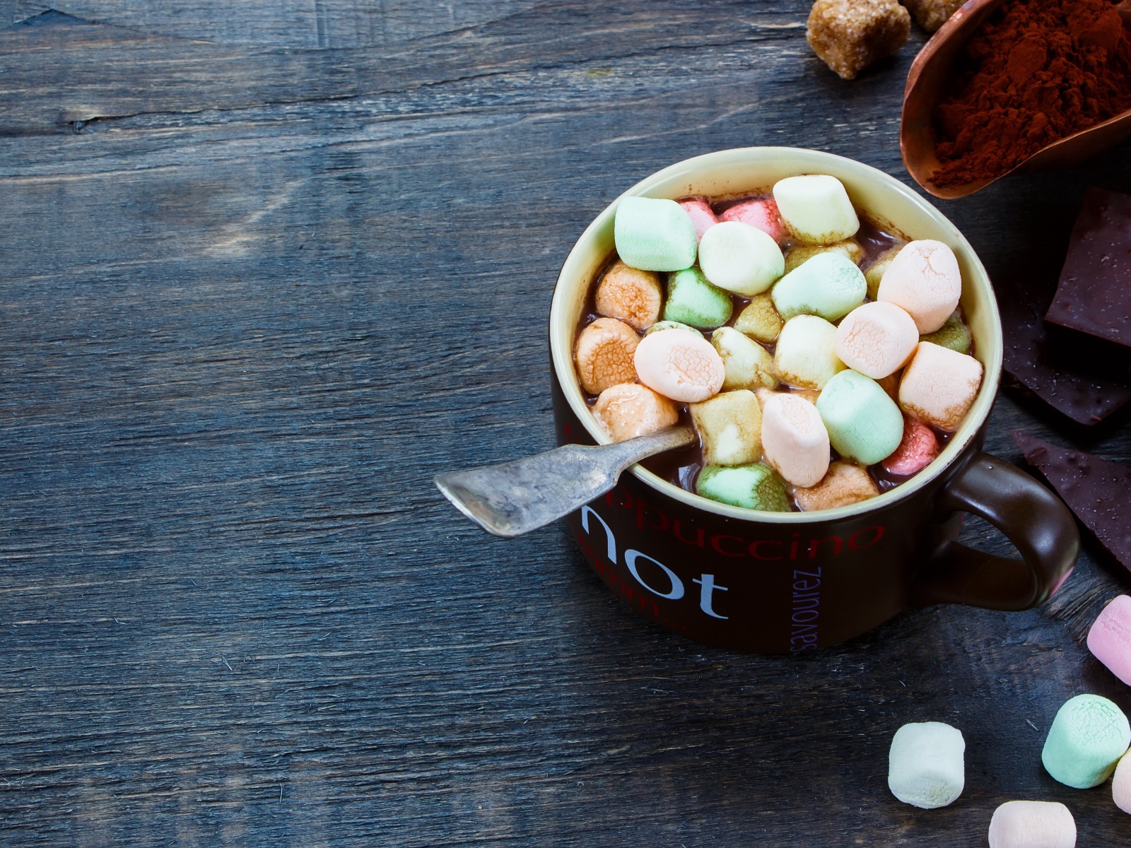 Горячий шоколад с маршмеллоу на столе с плитками