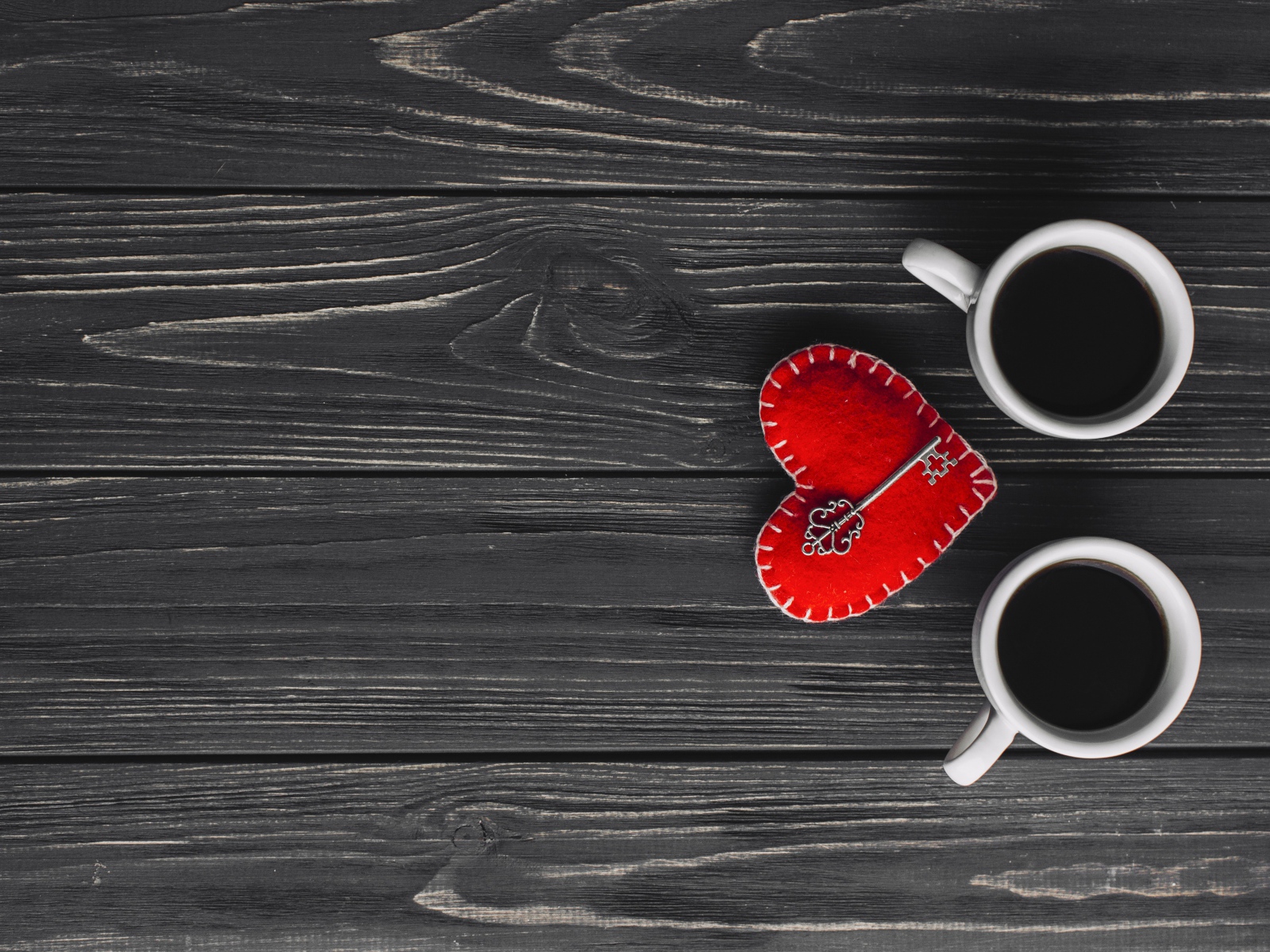 Две чашки кофе на столе с сердцем и ключом