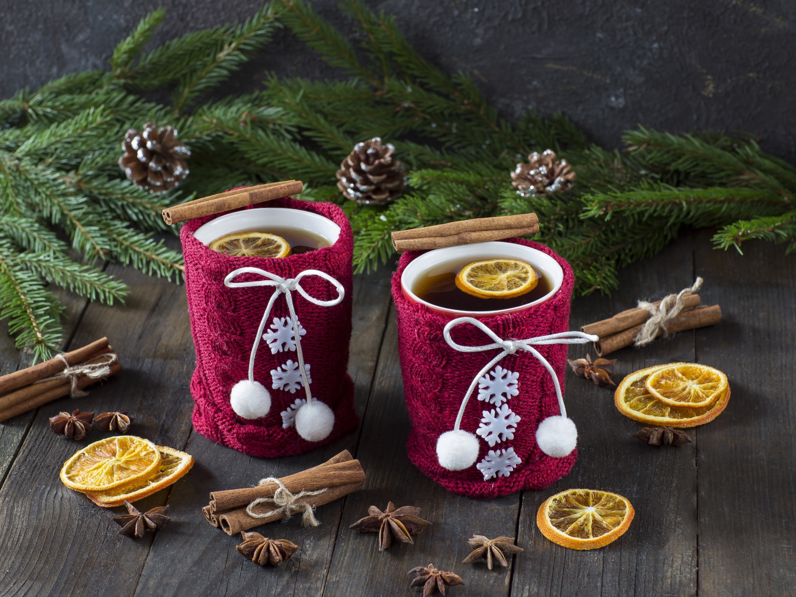 Две чашки горячего чая с лимоном на столе с еловыми ветками