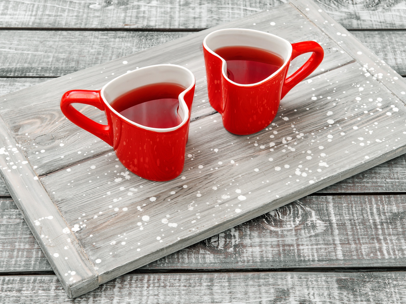 Две красные чашки в форме сердца на столе 