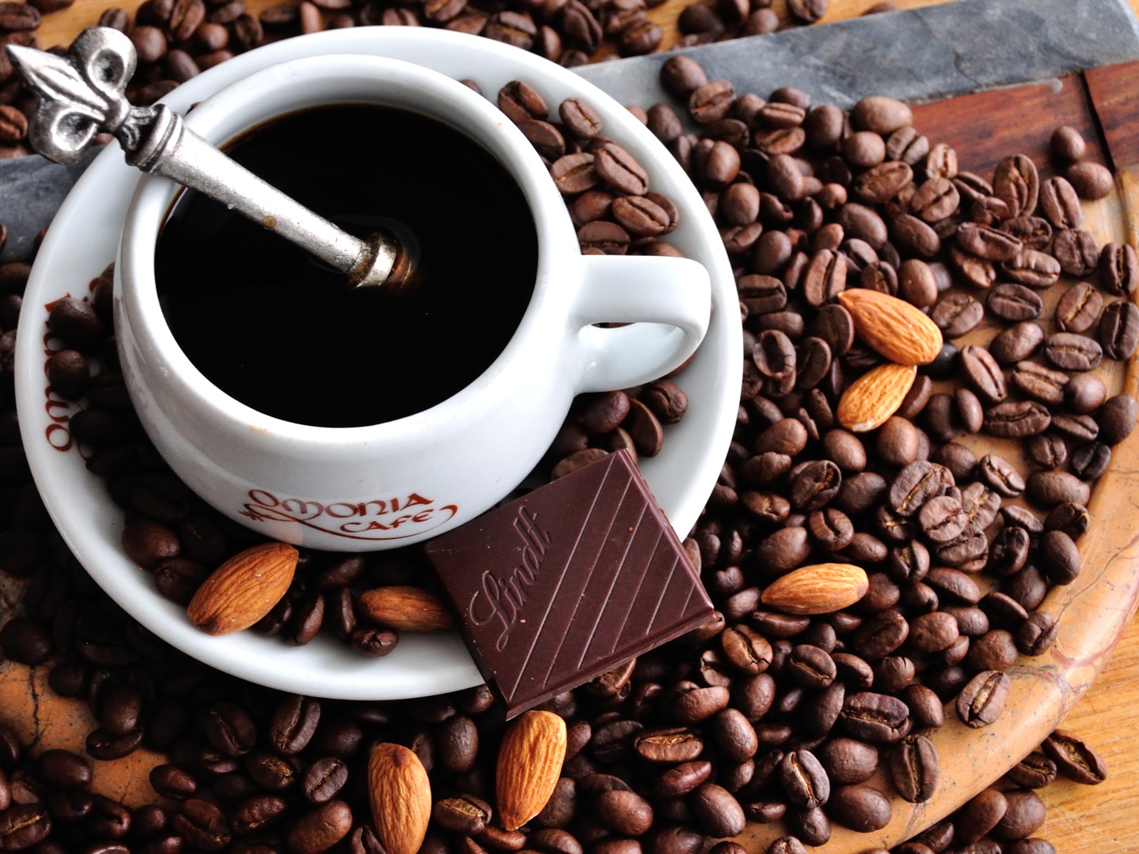 Белая чашка кофе на столе с кофейными зернами 