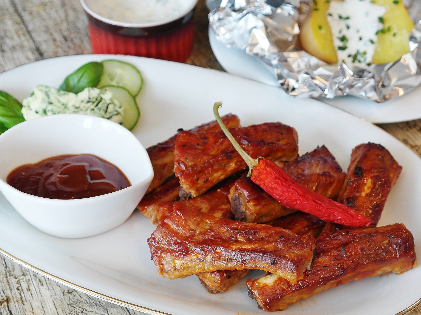 Ребрышки на тарелке с соусом и острым перцем