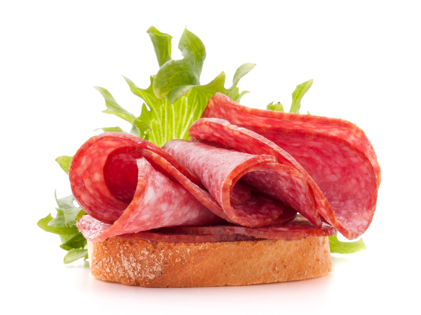 Бутерброд с листьями салата и колбасой на белом фоне