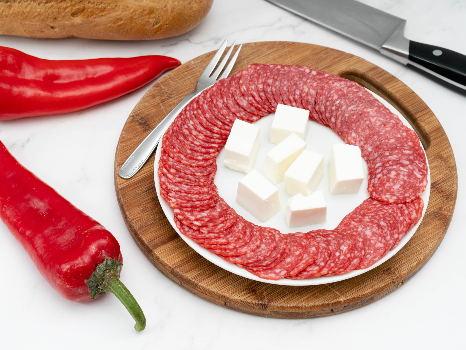 Колбаса с сыром на столе с красным сладким перцем