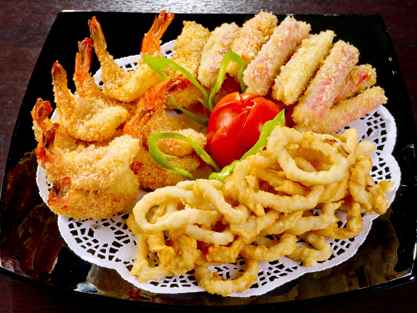 Морепродукты в кляре на тарелке с помидором