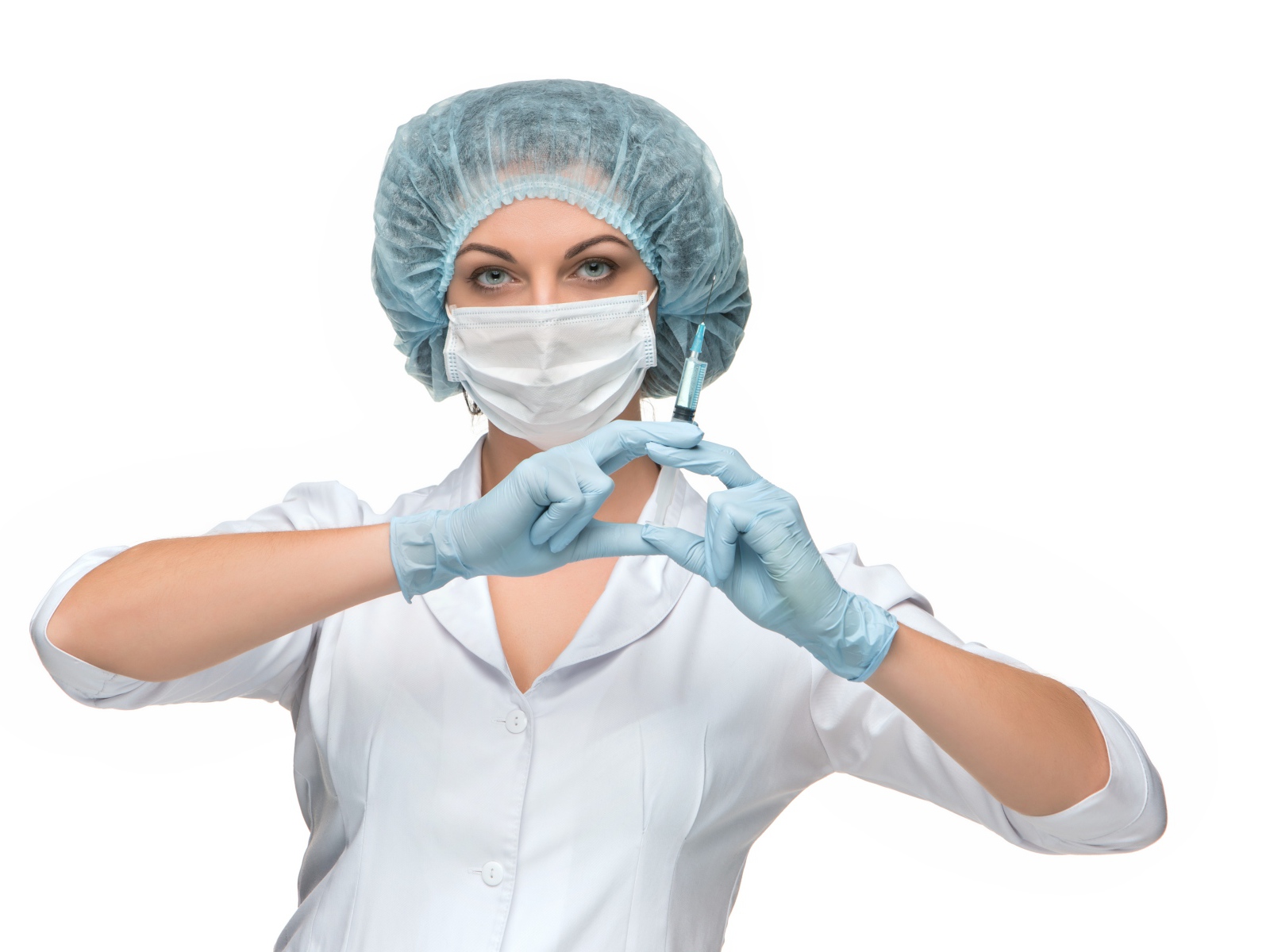 Девушка медсестра в маске со шприцем в руках на белом фоне